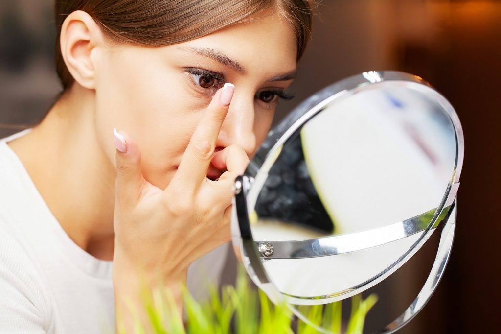 Contact lenses for vision. Close up of woman applying contact lenses