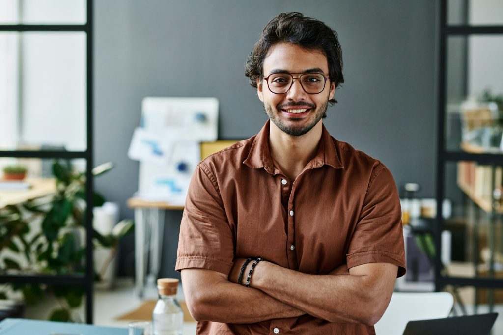 Young successful intern in eyeglasses and brown shirt